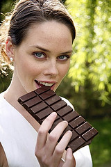 Young lady eating a bar of chocolate