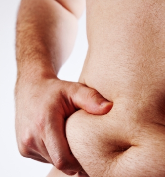 Man pinching stomach fat